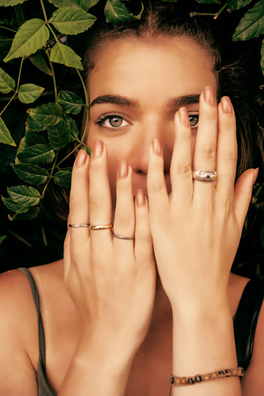 beautiful woman holding hands with healthy nails in front of her face