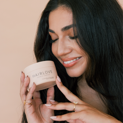 A Smiling Woman Holding HAIRLOVE Growth Complex