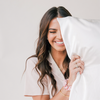 A Happy Woman Holding a Silk Pillow 