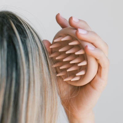 A Woman Massaging Hair with a Detox Scalp Massager